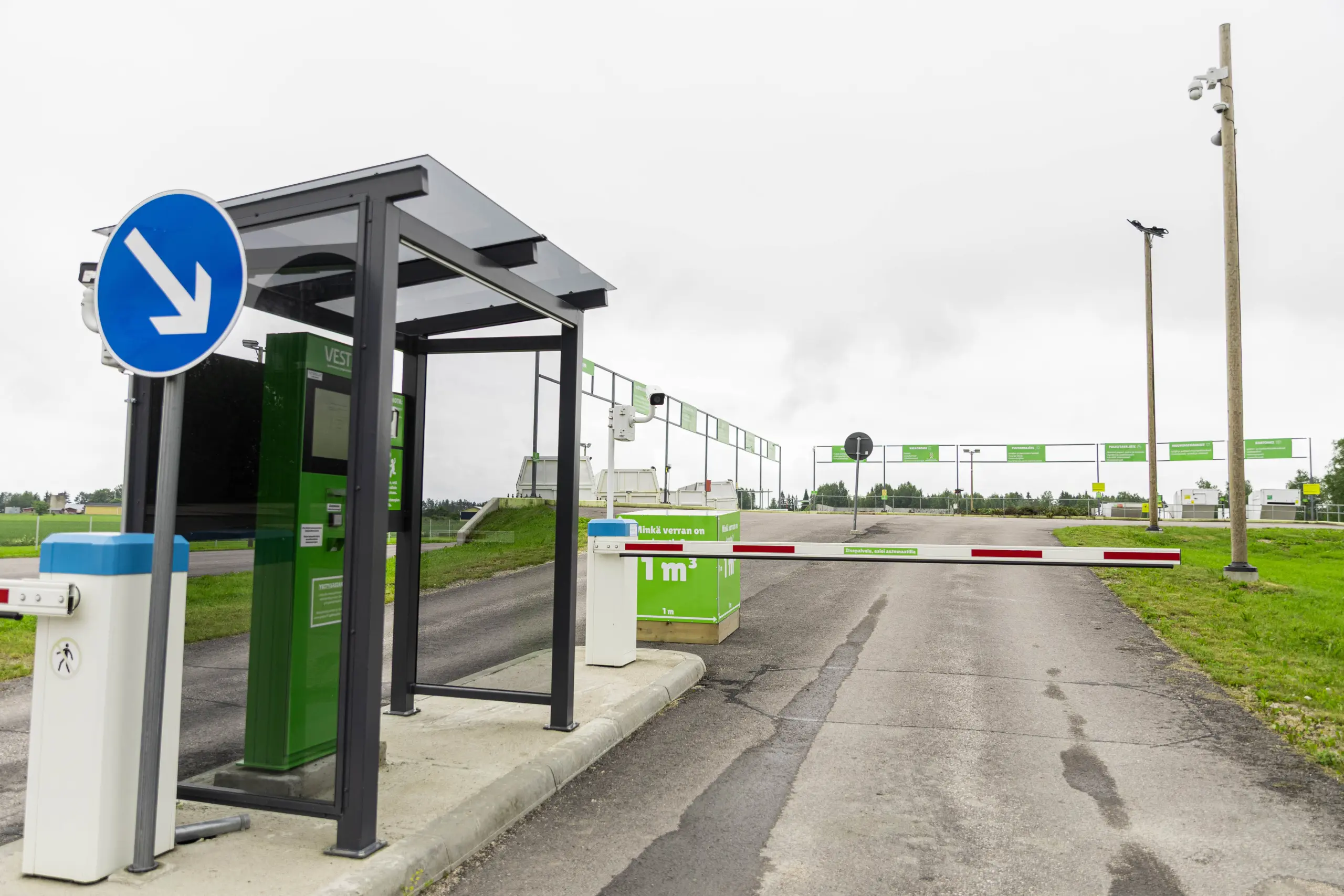 Lajittelupihan itsepalveluautomaatti vasemmassa reunassa, edessä alhaalla oleva puomi. Takana näkyy Nivalan lajittelupiha.