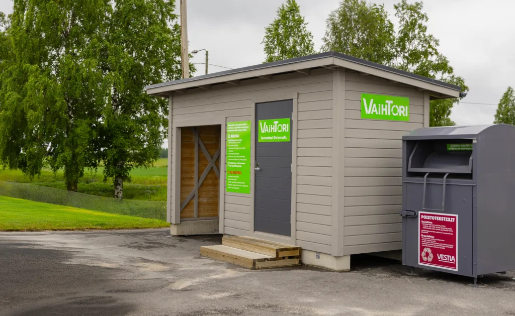 Vestian Vaihtori-kontti Nivalan lajittelupihalla. Harmaassa kontissa on vihreät kyltit, joissa lajitteluohjeet.
